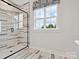 Contemporary bathroom featuring a frameless glass shower with marble-look tile surround and a window at 223 Halemarg Dr, Belmont, NC 28012