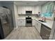 Updated kitchen featuring stainless steel appliances, white cabinets, stone countertops, and hardwood floors at 232 Harmony Hills Dr, Catawba, SC 29704