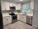 Modern kitchen with white cabinets, stainless steel appliances, stone countertops, and hardwood floors at 232 Harmony Hills Dr, Catawba, SC 29704