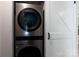 Modern laundry room featuring a stacked washer and dryer unit and a white sliding barn door at 232 Harmony Hills Dr, Catawba, SC 29704