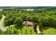 Aerial view of the property showcasing a large brick home, detached garage, and surrounding greenery at 234 Rivercliff Dr, Stony Point, NC 28678