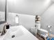 Clean bathroom featuring a bright white sink, toilet and shelving unit at 234 Rivercliff Dr, Stony Point, NC 28678