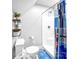 Compact bathroom with a toilet, shower, and functional storage shelving at 234 Rivercliff Dr, Stony Point, NC 28678