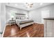 Well-lit bedroom with a decorative bed frame, matching nightstands, and gleaming wood floors at 234 Rivercliff Dr, Stony Point, NC 28678
