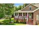 Charming brick home with a welcoming front porch, beautiful landscaping, and a well-manicured lawn at 234 Rivercliff Dr, Stony Point, NC 28678