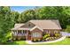 Charming brick home featuring a landscaped front yard, covered porch, and well-manicured shrubbery at 234 Rivercliff Dr, Stony Point, NC 28678