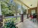 Relaxing front porch with white railings, brick columns, and comfortable seating area with greenery at 234 Rivercliff Dr, Stony Point, NC 28678