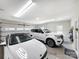 Garage features two white cars, overhead lighting, door windows and coat hanging station at 234 Rivercliff Dr, Stony Point, NC 28678