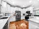 Modern kitchen with stainless steel appliances, white cabinetry, and a stylish backsplash and hardwood floors at 234 Rivercliff Dr, Stony Point, NC 28678