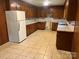 Spacious kitchen featuring wood cabinets, tile flooring, and a white refrigerator, perfect for upgrades at 237 Antietam Rd, Statesville, NC 28625