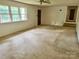 Bright living room featuring multiple windows, neutral carpet, and a ceiling fan for added comfort at 237 Antietam Rd, Statesville, NC 28625