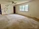 Open living room featuring large windows providing ample natural light and a ceiling fan for comfort at 237 Antietam Rd, Statesville, NC 28625