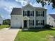 Traditional two-story home showcasing black shutters, an attached garage, and a well-maintained lawn at 2819 Cougar Hill Ct, Charlotte, NC 28216