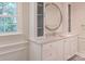 Bathroom boasts a sleek vanity with marble counters, a round mirror, and storage cabinets, offering a clean design at 3008 Heathcroft Ct, Charlotte, NC 28269