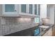 Close-up of a kitchen sink area with mosaic backsplash, dark countertop, and white cabinets at 3008 Heathcroft Ct, Charlotte, NC 28269
