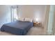 Relaxing main bedroom with a cozy bed, elegant side tables, and bright, airy ambiance from the large window at 3008 Heathcroft Ct, Charlotte, NC 28269