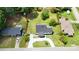 Aerial view of a home with a gray roof, white siding, front porch, gravel driveway, fenced front and side yards at 307 W Sunset Dr, Moore, NC 28110