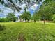 Large grassy backyard with mature trees and a view of the house at 307 W Sunset Dr, Moore, NC 28110