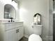 Bright bathroom featuring marble shower, toilet, and a sink with black hardware at 307 W Sunset Dr, Moore, NC 28110