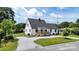Exterior elevation of a house with gray roof, white siding, front porch, black door and window trim, and landscaped garden at 307 W Sunset Dr, Moore, NC 28110