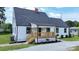 Exterior elevation of a house with gray roof, white siding, front porch, black door and window trim, and landscaped garden at 307 W Sunset Dr, Moore, NC 28110