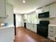 Updated kitchen with white cabinets, black appliances, and wood-look floors at 307 W Sunset Dr, Moore, NC 28110