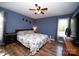 Relaxing main bedroom with calming blue walls, hardwood flooring, ceiling fan, and abundant natural light at 3330 Clinzo Feemster Rd, Hickory Grove, SC 29717