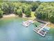 Stunning aerial view showcasing a private dock with multiple boat slips, surrounded by lush greenery and clear water at 345 Beaten Path Rd, Mooresville, NC 28117