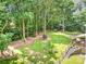 Serene backyard with a wooden fence, lush greenery, and a spacious deck, perfect for relaxation and outdoor activities at 345 Beaten Path Rd, Mooresville, NC 28117