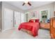 Spacious bedroom boasts a red bed, three windows, a ceiling fan, and access to an ensuite bathroom and closet at 345 Beaten Path Rd, Mooresville, NC 28117