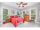 Bright bedroom featuring a red bed, two dressers, a ceiling fan, and natural light from multiple windows at 345 Beaten Path Rd, Mooresville, NC 28117