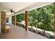 Covered porch with wood decking, stone accents, modern railing, and a ceiling fan, offering serene outdoor living at 345 Beaten Path Rd, Mooresville, NC 28117