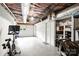 Unfinished basement area with concrete floor, garage door, utility closet and gym equipment at 3504 Mountainbrook Rd, Charlotte, NC 28210
