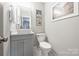 Modern powder room featuring a white vessel sink, gray vanity, and tile floor at 3504 Mountainbrook Rd, Charlotte, NC 28210