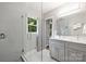 Bathroom with a dual sink vanity, walk-in glass shower, and gray tile at 3504 Mountainbrook Rd, Charlotte, NC 28210