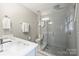 Modern bathroom with a glass-enclosed shower and dual sink vanity with white countertop and gray cabinets at 3504 Mountainbrook Rd, Charlotte, NC 28210