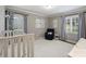 Calm Bedroom with light gray walls, a crib, and a comfortable chair near the window at 3504 Mountainbrook Rd, Charlotte, NC 28210