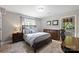 This bedroom features a comfortable bed, two dressers, a window, and an outside entry door at 3504 Mountainbrook Rd, Charlotte, NC 28210