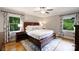 Cozy bedroom with a large window, hardwood floors, and king size bed with side tables and matching lamps at 3504 Mountainbrook Rd, Charlotte, NC 28210