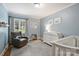 Bright Bedroom with a crib, changing table, and blue walls with light wood flooring at 3504 Mountainbrook Rd, Charlotte, NC 28210