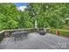 Large deck with outdoor dining table and chairs overlooks the lush, green backyard at 3504 Mountainbrook Rd, Charlotte, NC 28210