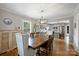 Dining room with hardwood floors, modern light fixture, and direct view into the kitchen at 3504 Mountainbrook Rd, Charlotte, NC 28210