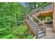 Multi-level wood deck stairway with aluminum railings leading to a wooded back yard at 3504 Mountainbrook Rd, Charlotte, NC 28210