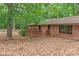 Brick home with a wood deck, surrounded by mature trees and foliage at 3985 Well Rd, Mint Hill, NC 28227
