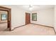 Bedroom with wood trim, carpet, and natural light from the window, complemented by closet and door at 3985 Well Rd, Mint Hill, NC 28227