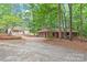 A brick home with well-kept garages and driveways shows a property nestled amongst mature trees at 3985 Well Rd, Mint Hill, NC 28227