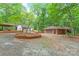Charming brick home with a long driveway, lush trees, and a separate garage at 3985 Well Rd, Mint Hill, NC 28227