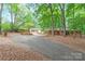 Charming brick home with a long driveway, lush trees, and a separate garage at 3985 Well Rd, Mint Hill, NC 28227