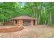 Detached garage with a brick exterior and brown garage door at 3985 Well Rd, Mint Hill, NC 28227
