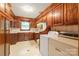 Functional laundry room with wooden cabinets, tile backsplash, white appliances, and classic design elements at 3985 Well Rd, Mint Hill, NC 28227